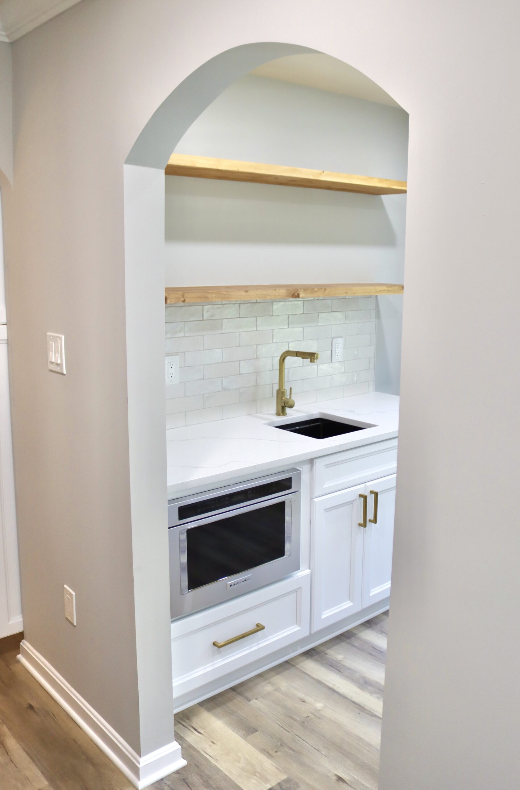 Hidden scullery prep sink with natural wood floating shelves in Accokeek, MD