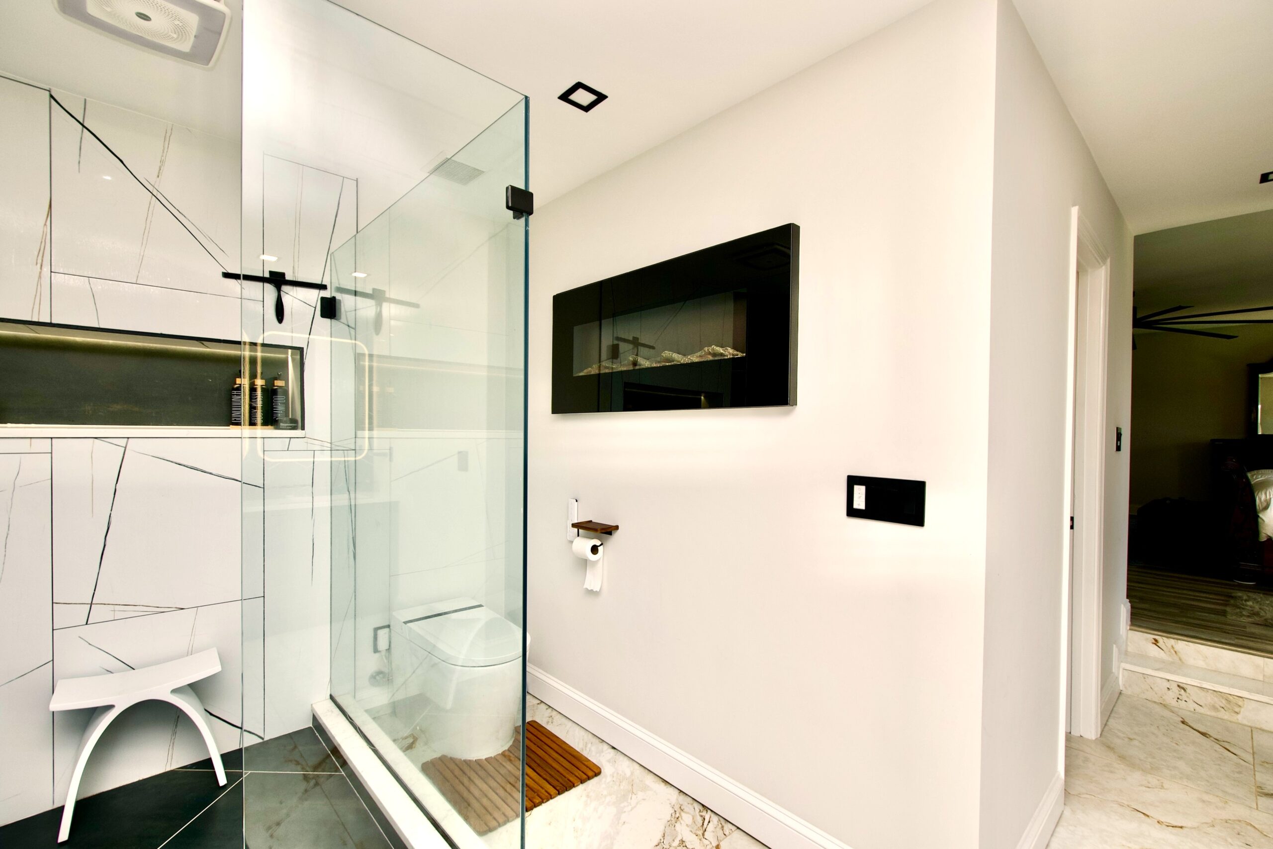 Bathroom fireplace paired with glass shower in Fort Washington MD luxury remodel