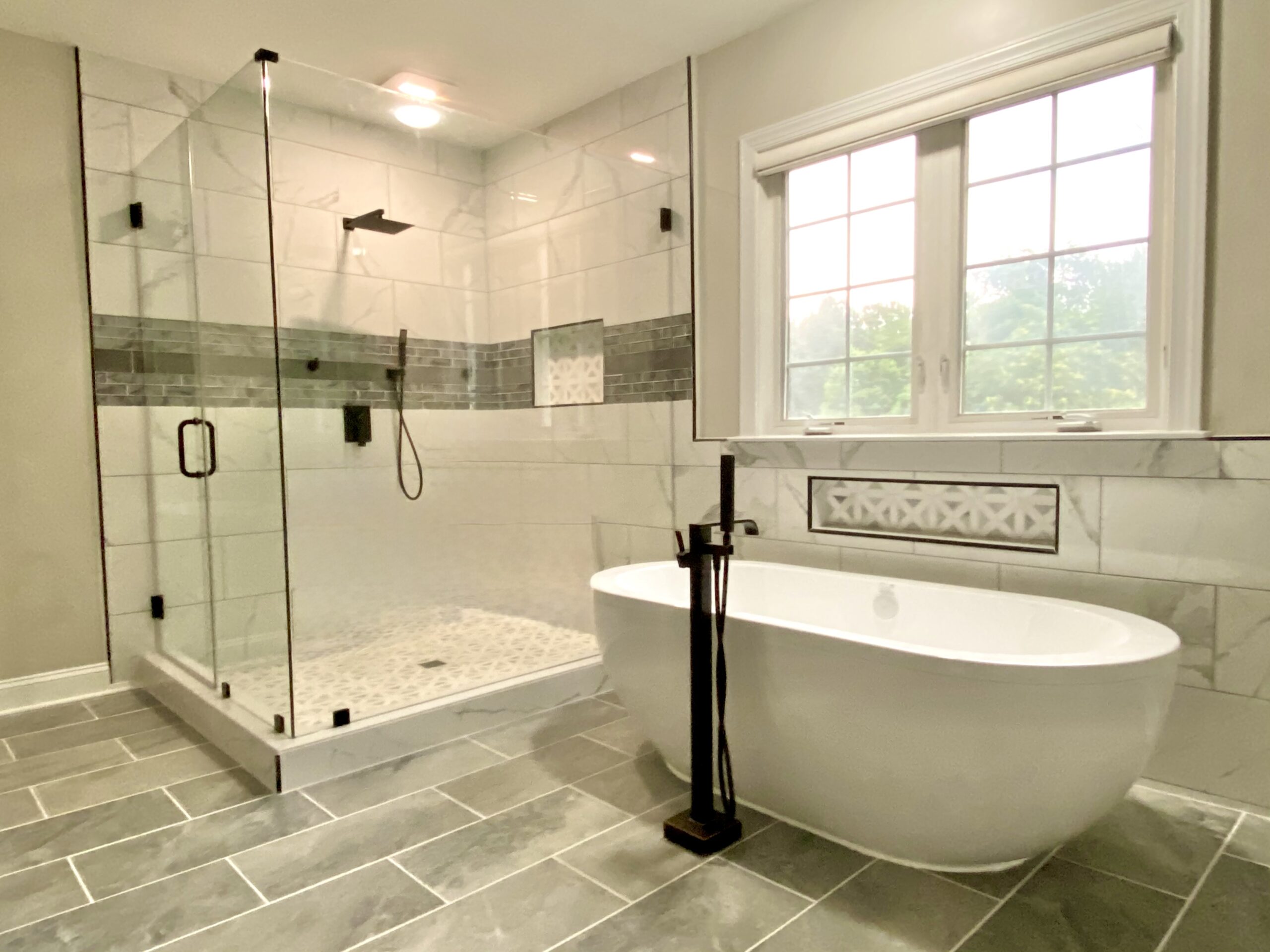 Luxury master bath in Accokeek Maryland with freestanding tub and large glass shower by MSH Signature.