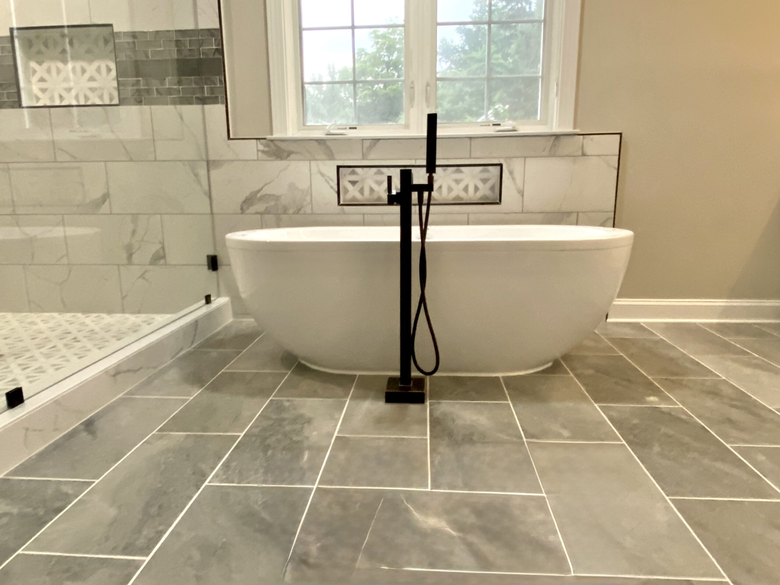 Freestanding tub and tub filler installation in Accokeek Maryland master bathroom.