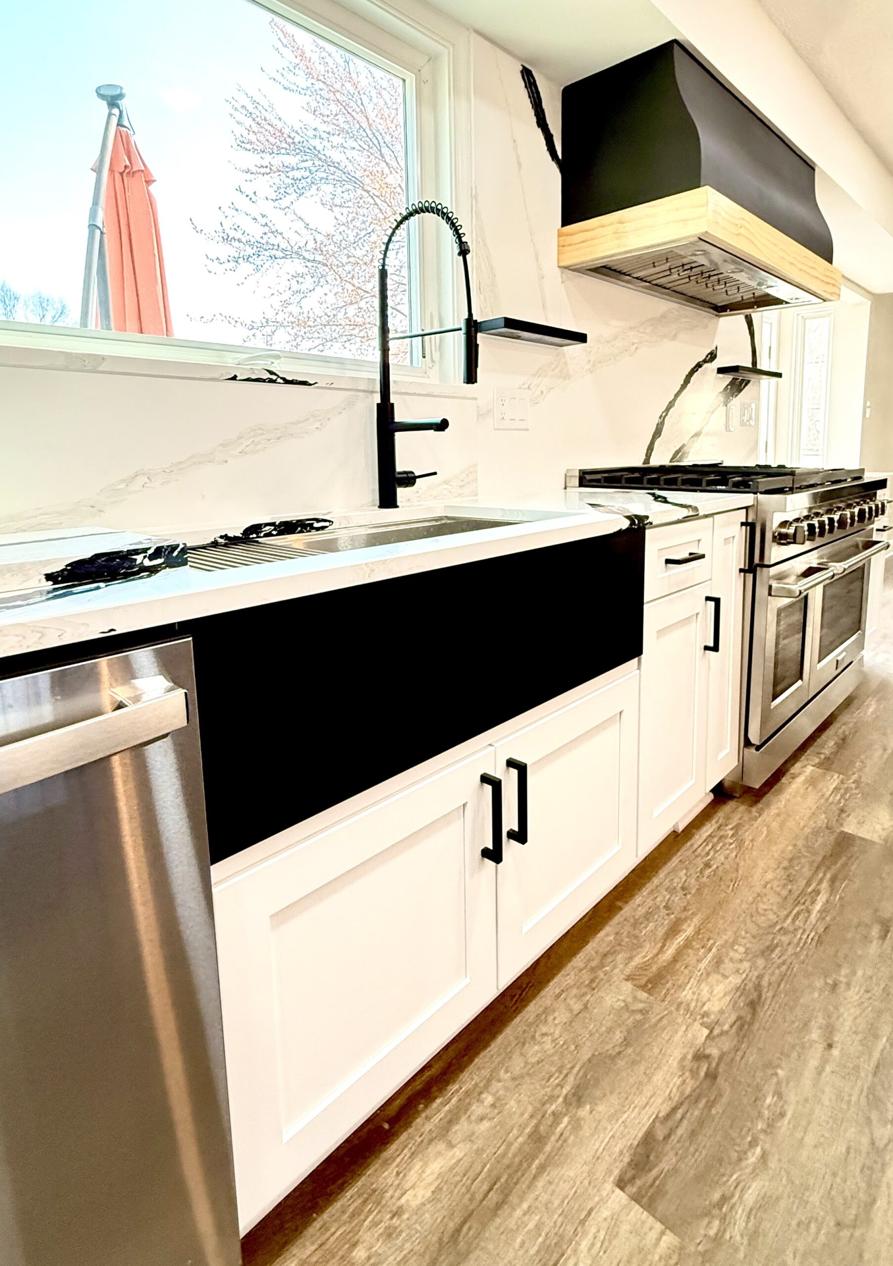 Farmhouse sink with custom wood range hood and quartz surfaces in Fort Washington, MD
