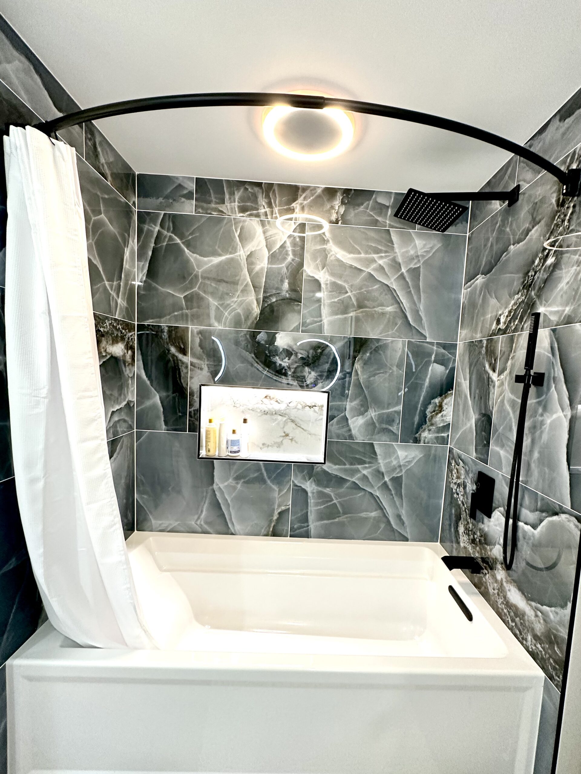 Tub and shower remodel in Accokeek Maryland with blue onyx-look tile.