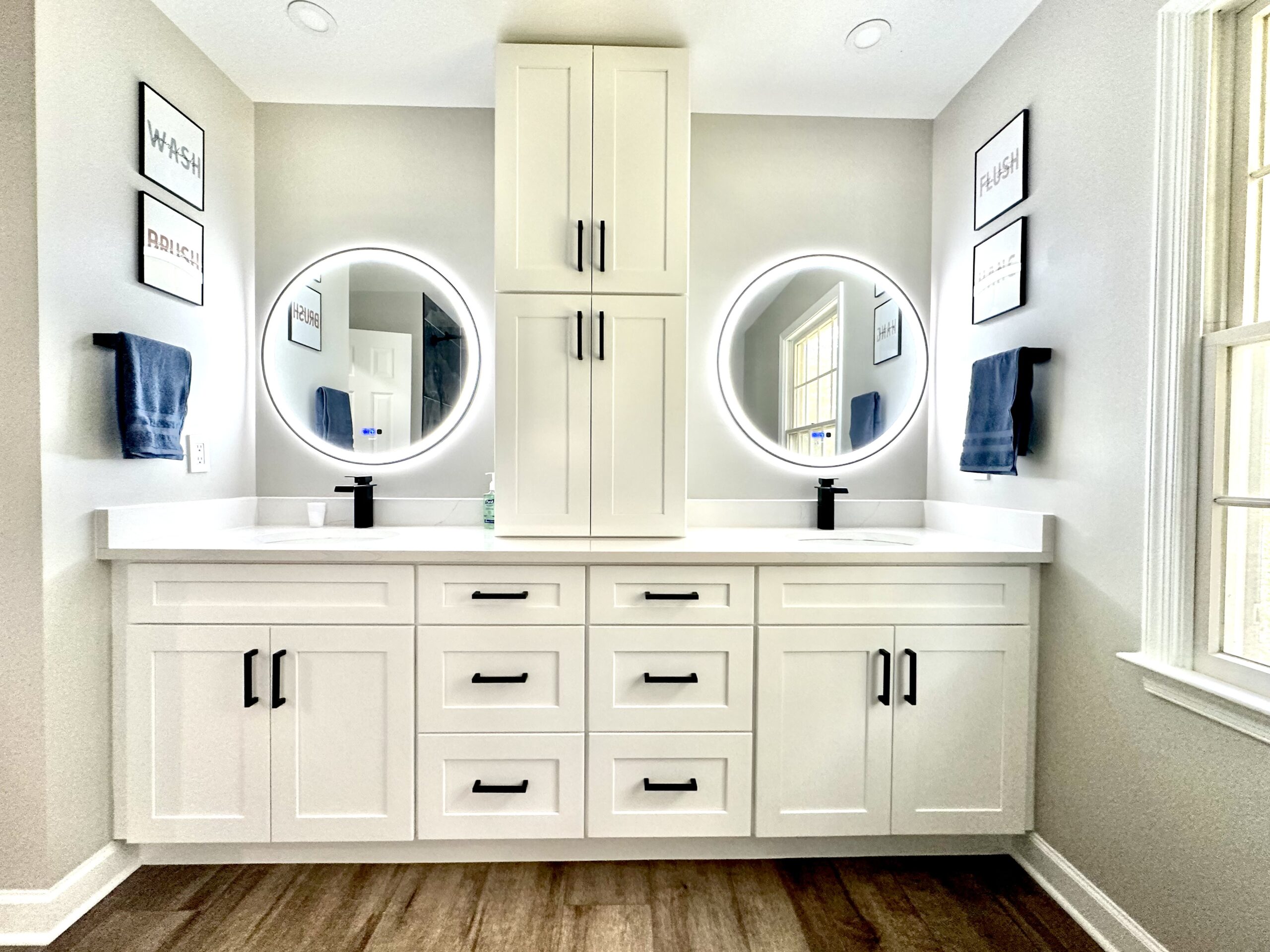 White double vanity bathroom remodel in Accokeek Maryland with circular LED mirrors.